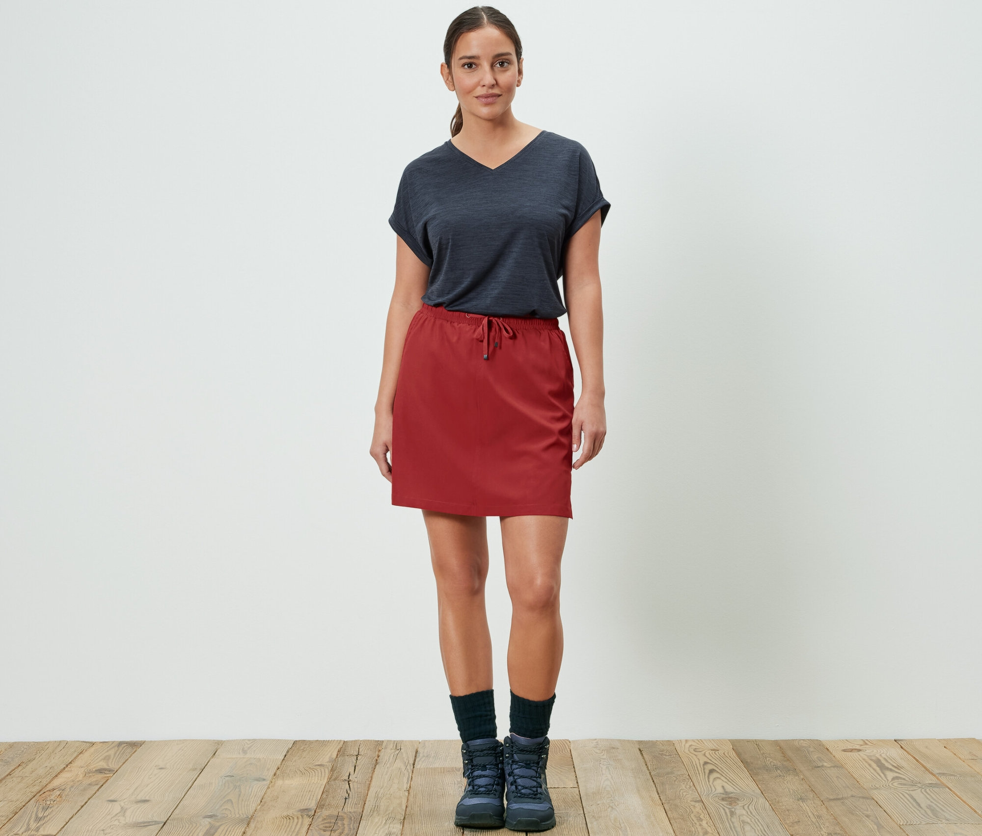 Frau posiert in roten Funktionsrockshorts.