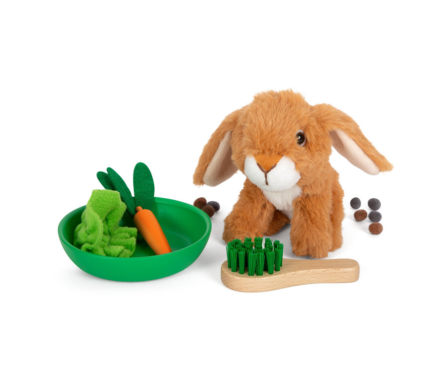 Ein braunes Stofftier-Häschen sitzt neben einer grünen Schale mit Spielzeug und einer Holzbürste.