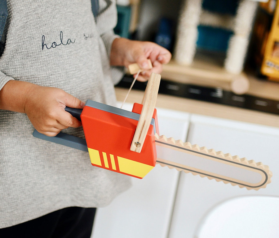 Junge hält eine small foot Kettensäge.