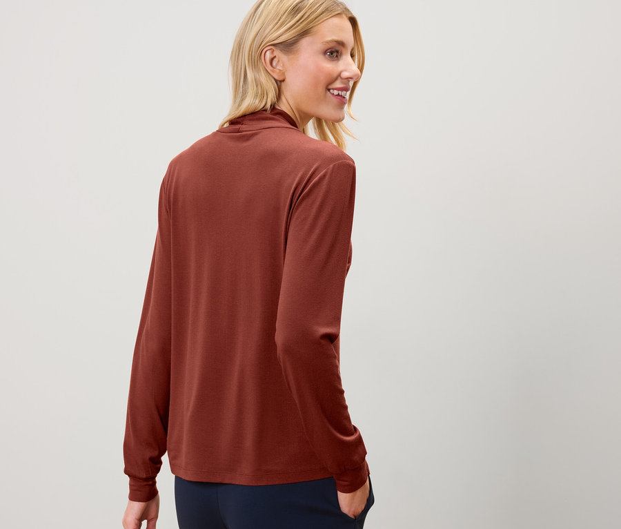 Blonde Frau trägt ein Blusenshirt mit V-Ausschnitt.