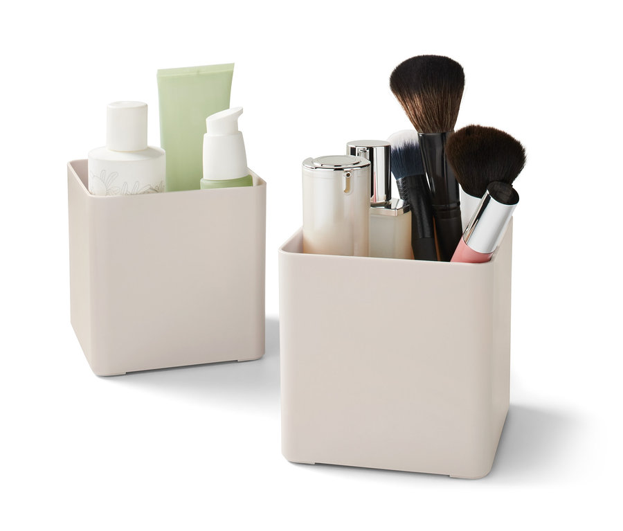 Zwei beige Organizer, einer mit Kosmetika und einer mit Pinseln.