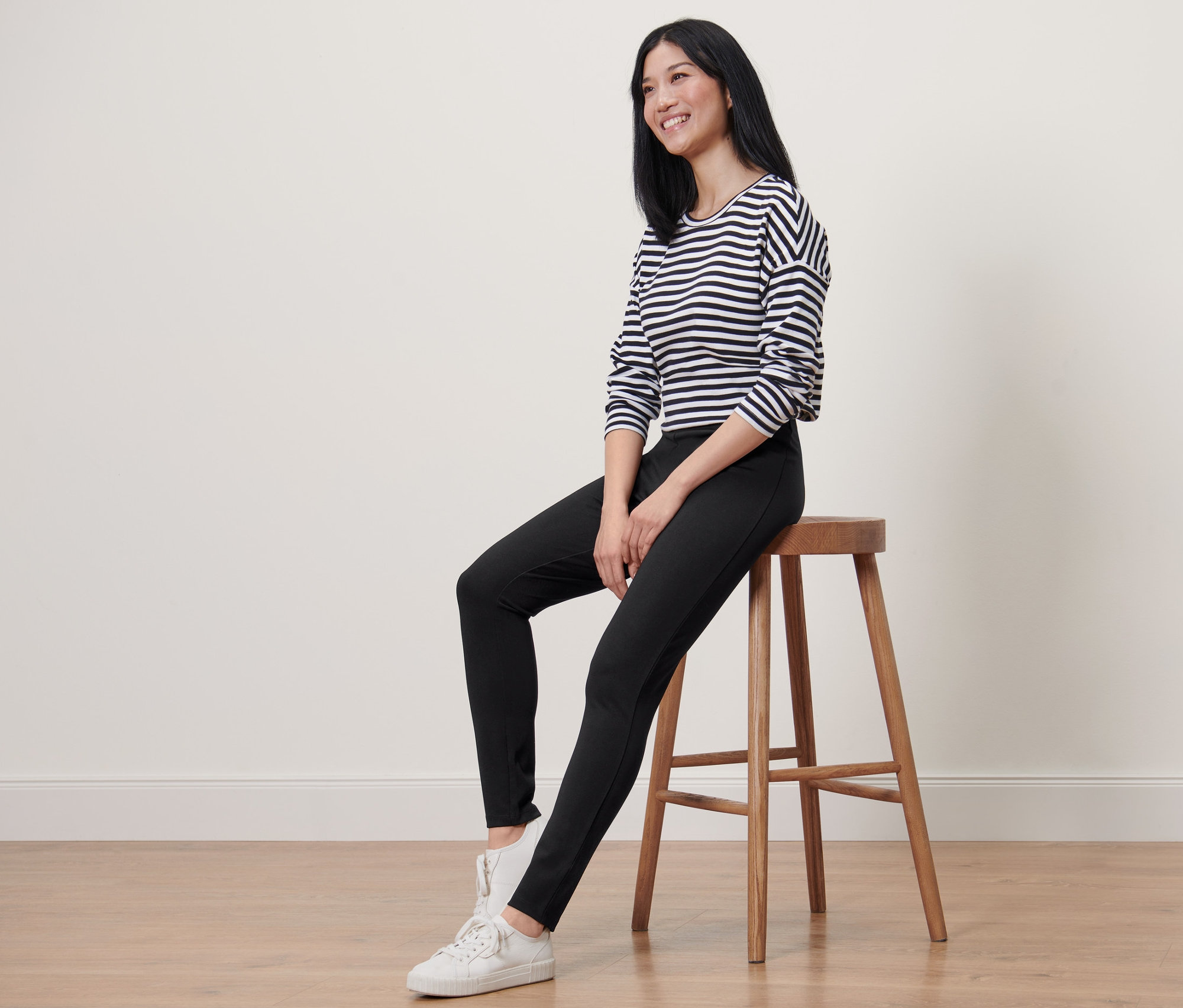 Frau sitzt auf einem Hocker und trägt Heavy-Leggings.