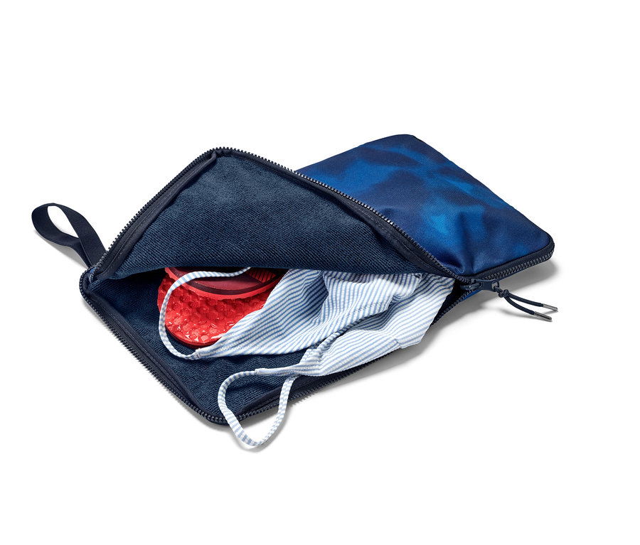 Offene blaue Umzieh-Unterlage-und-Nasssack mit roten Schuhen und gestreiftem Oberteil darin.