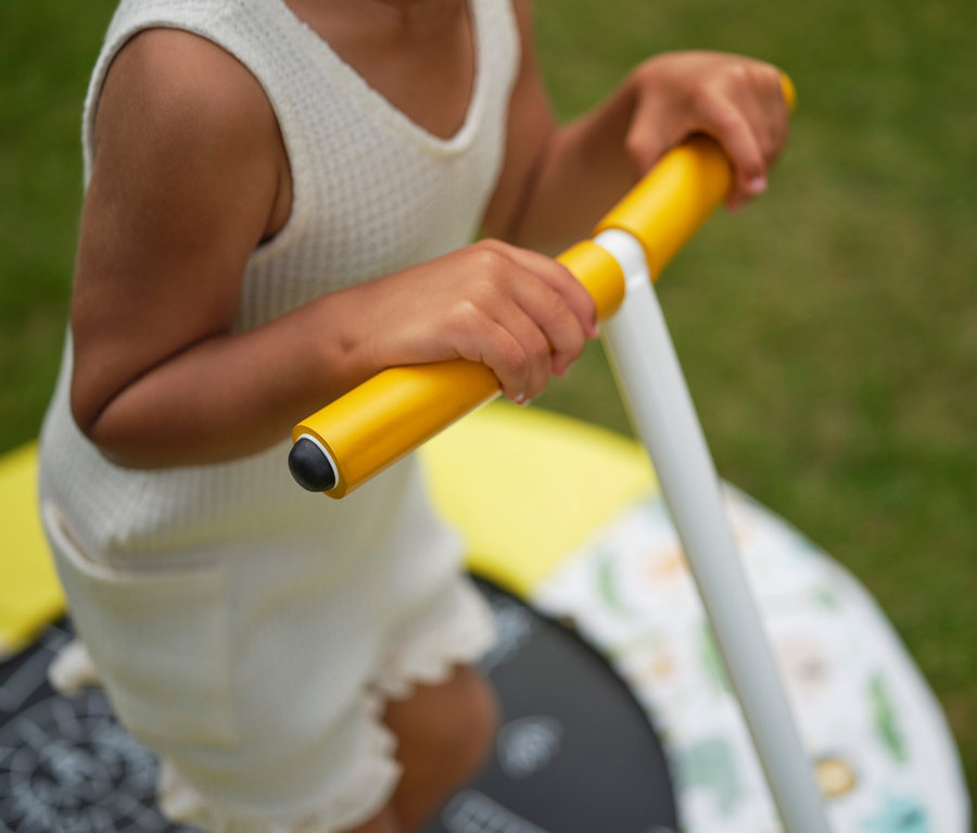Kind hält gelbe Stange am Plum Kinder-Trampolin »Junior Bouncer« mit Dschungel-Sound.