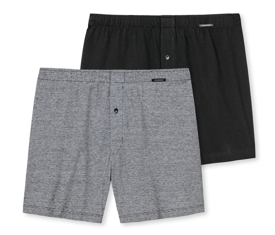 Zwei SCHIESSER Boxershorts aus Baumwolle, eine schwarze und eine graue, liegen übereinander.
