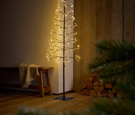 Dekorativer Baum mit Ästen und LED-Leuchten steht in einem Innenraum.