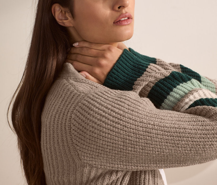 Frau posiert in offener Strickjacke.