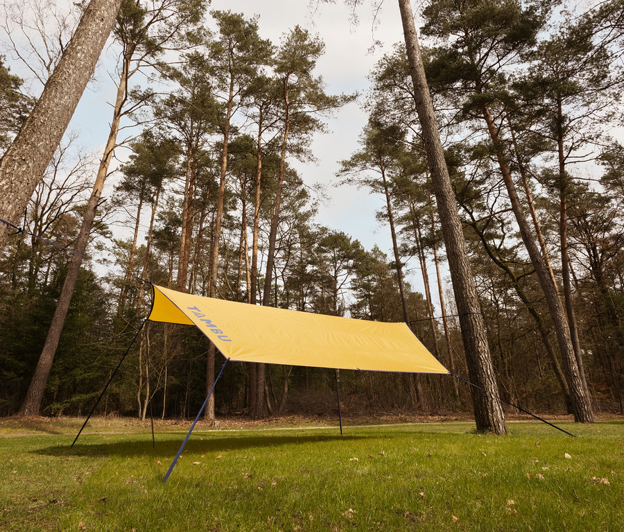 Kleines, gelbes Tambu Sonnensegel CHADA, das zwischen Bäumen im Wald aufgespannt ist.