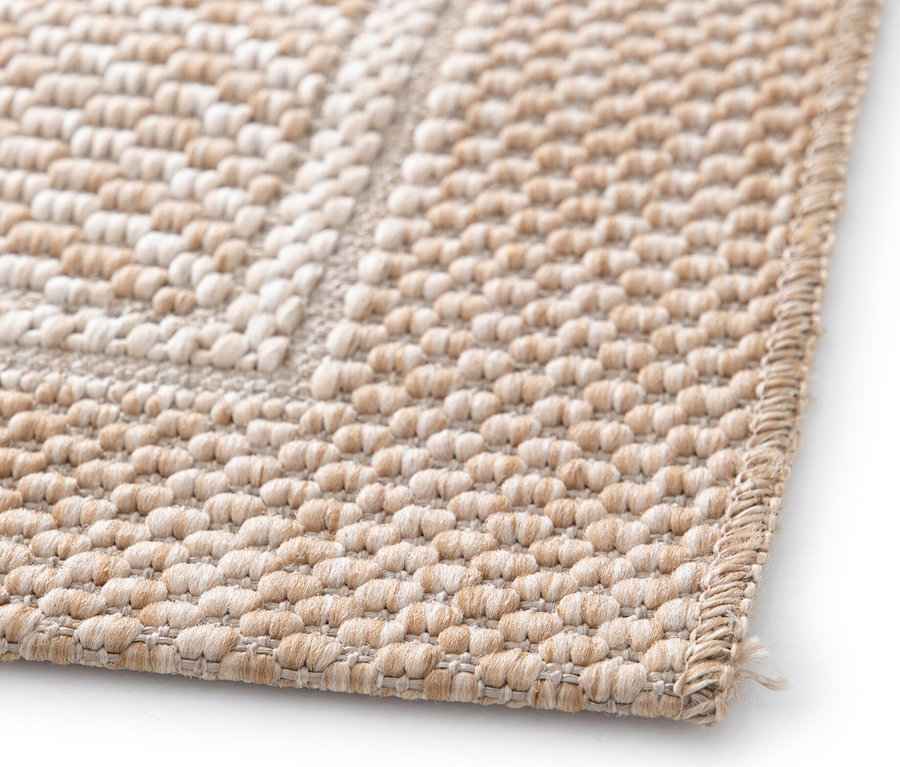 Nahaufnahme eines beige farbenen Teppichs »Twine« mit dezentem Fischgrätmuster.