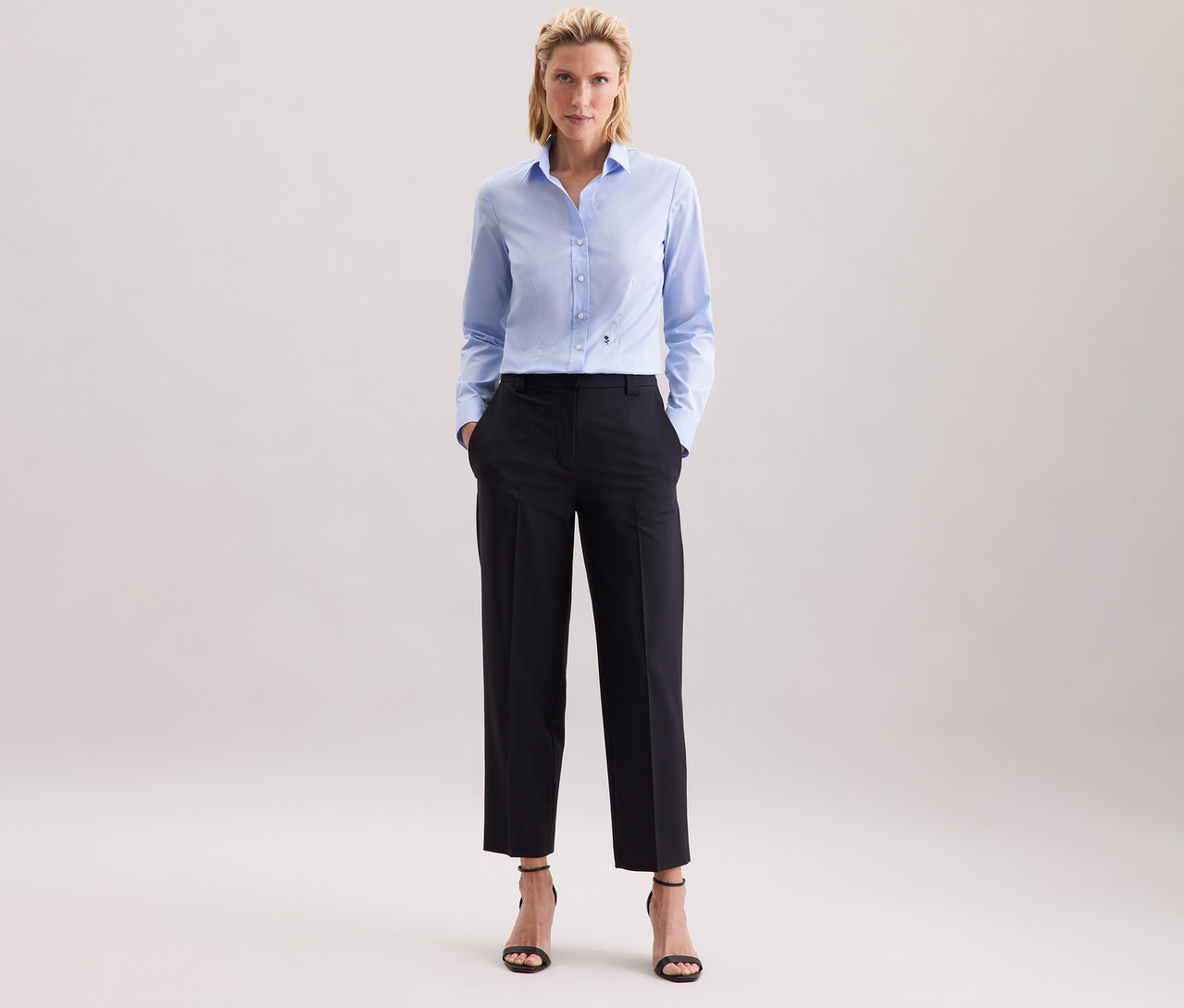 Frau mit hellblauer Seidensticker Bluse Slim Fit non iron und dunkler Hose.