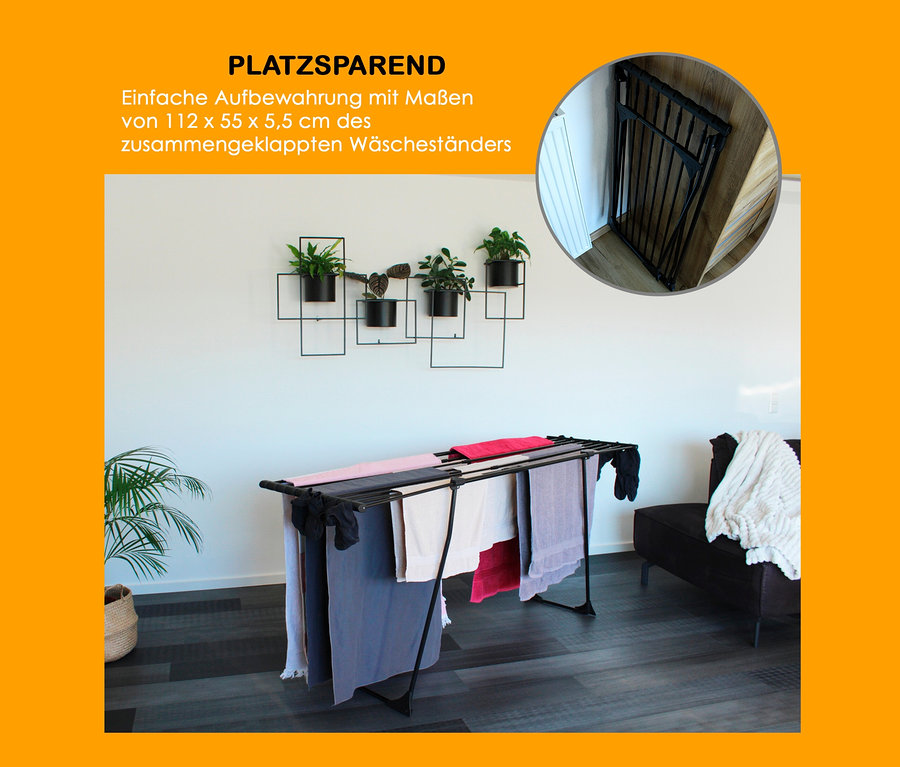 Schwarzer Teleskop-Wäscheständer mit bunter Wäsche steht im Wohnzimmer.