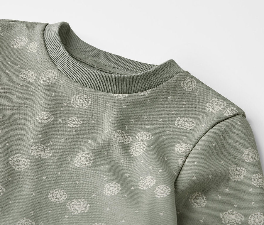 Detailansicht eines grünen Sweat-Kombis mit Löwenzahn-Muster.