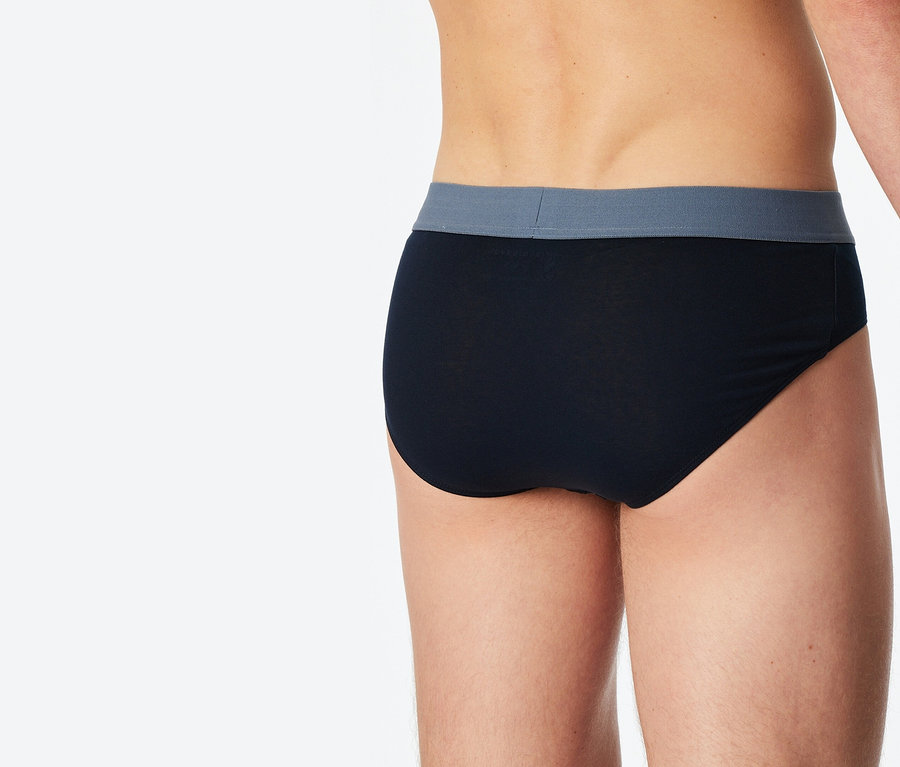 Nahaufnahme der Rückansicht einer Person, die eine schwarze Unterhose mit einem grauen Bund trägt.