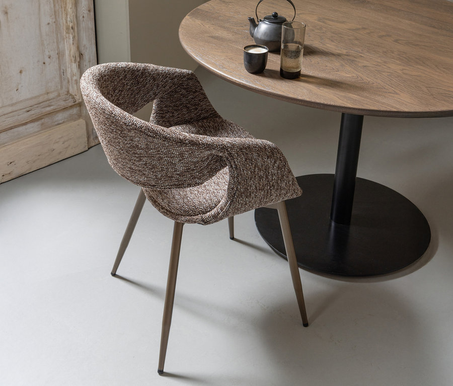 Ein kupfer-brauner WOOOD Esszimmerstuhl »Yossi« mit Metallfuß (aus einem 2er-Set) steht neben einem runden Holztisch mit Teekanne und Gläsern.