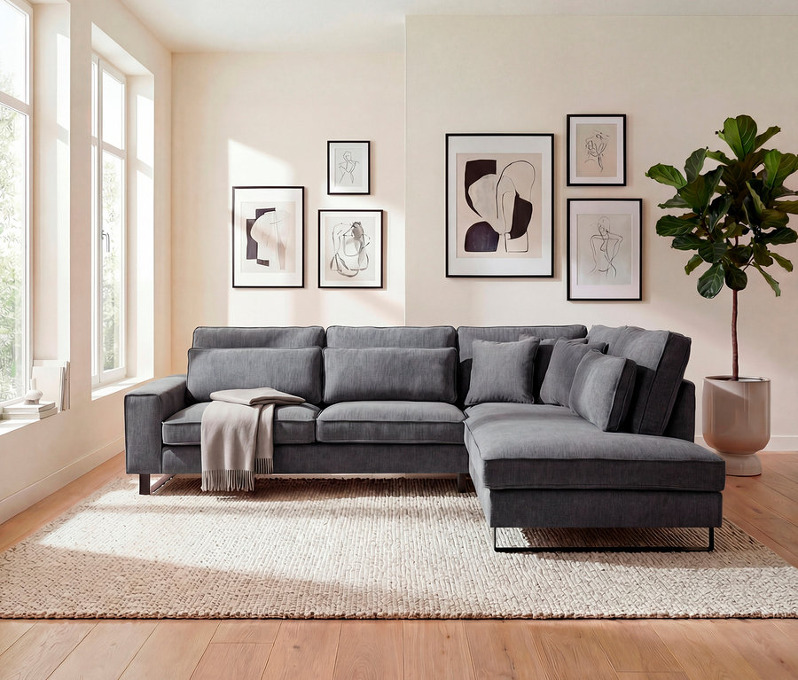 Graues Ecksofa mit Kissen und Decke im Wohnzimmer mit Kunstwerken an der Wand.