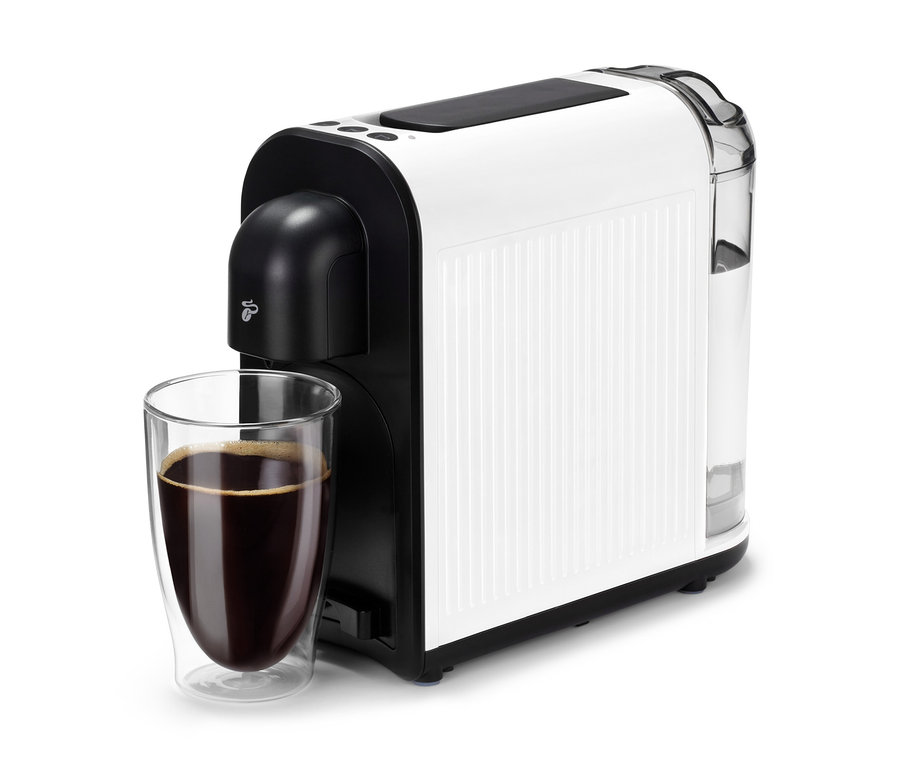 Eine weiße Cafissimo now white Kaffeemaschine mit einer Tasse Kaffee davor.