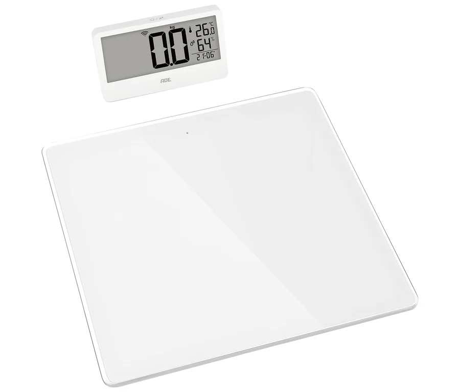 Weiße digitale Personenwaage mit separatem Display, das 0,0 kg, 26,0 °C, 64 % Luftfeuchtigkeit und 21:06 Uhr anzeigt.