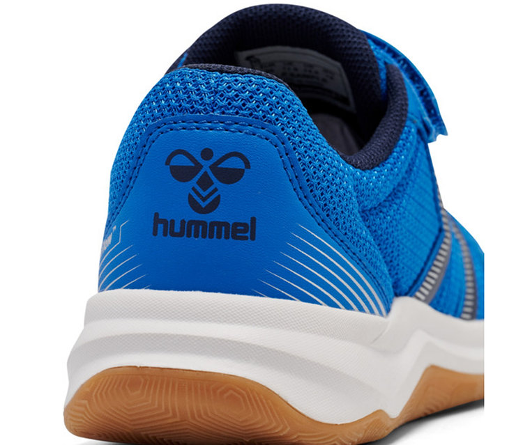 Nahaufnahme der Ferse eines blauen Sportschuhs mit Hummel-Logo, weißer Zwischensohle und brauner Gummisohle.