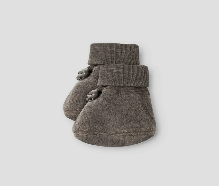 Ein Paar graubraune Babyschühchen mit gerippten Bündchen und zwei kleinen Zierknöpfen an der Seite jedes Schühchens.