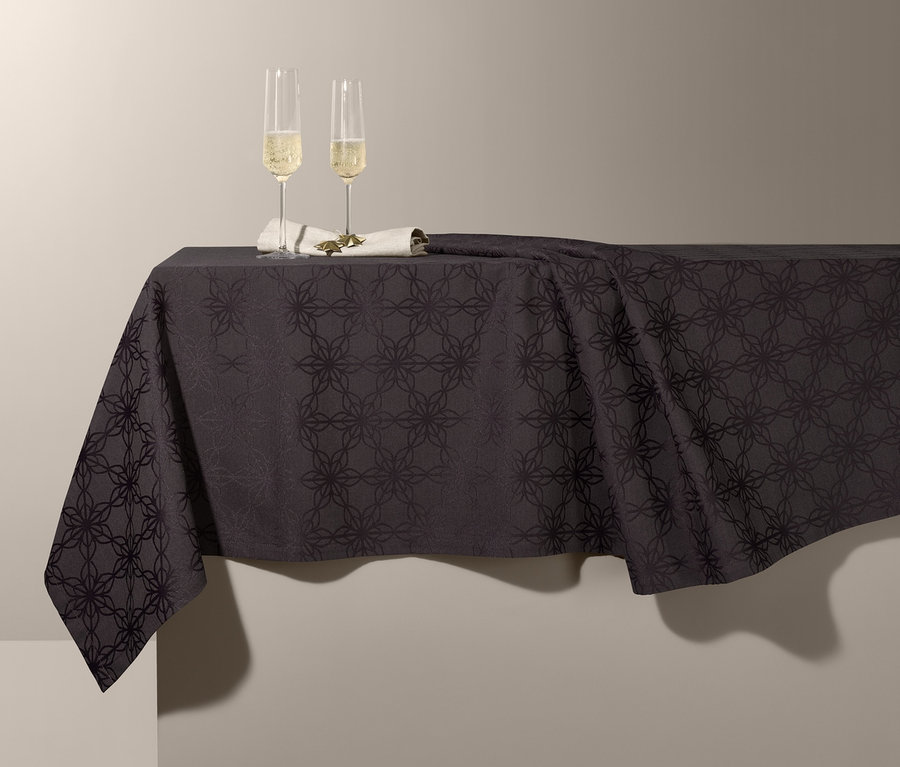 Zwei Champagnergläser auf einer Jacquard-Tischdecke.
