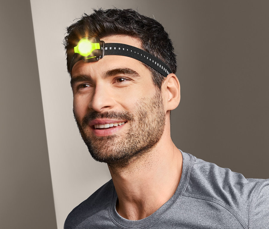 Mann trägt eine kompakte Stirnlampe.