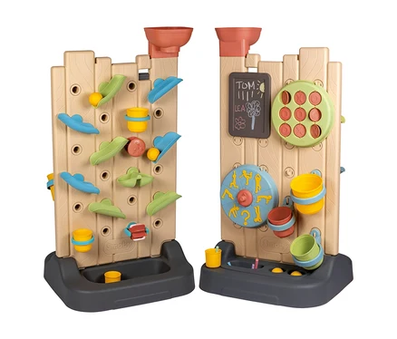 Zwei beigefarbene Smoby Life Activity Walls, die Holzzäunen ähneln, stehen nebeneinander. Die linke Wand zeigt eine bunte Wasser- und Kugelbahn mit Trichtern und Eimern. Die rechte Wand hat eine Tafel, ein Tic-Tac-Toe-Spiel und ein drehbares Aktivitätsrad, ebenfalls mit Trichtern und Eimern. Beide Wände haben dunkelgraue Basen.