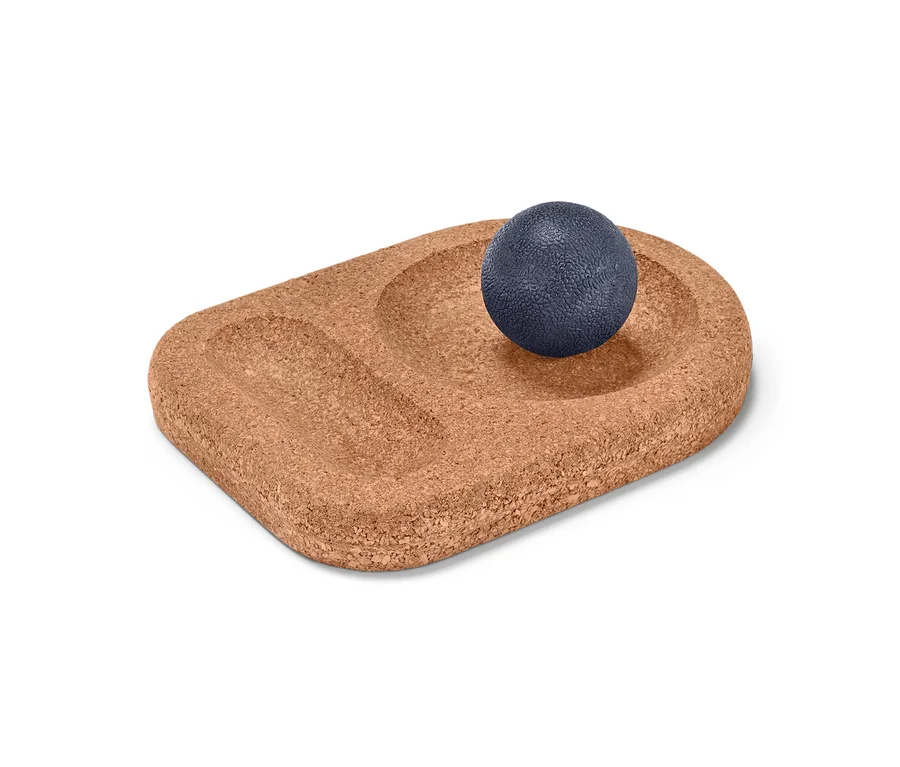 Blauer Massageball auf Korkunterlage mit Aussparungen aus Fußmassageset.