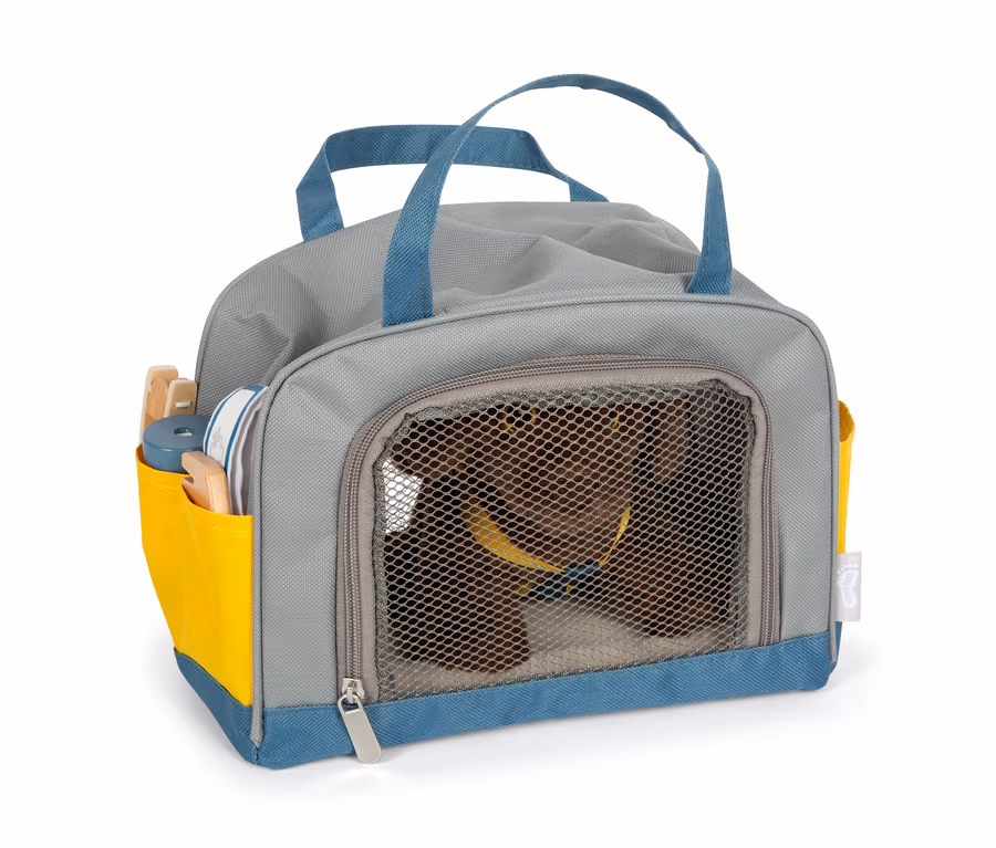 Ein brauner Plüschhund in einer grauen small foot Tasche mit blauen Akzenten und gelber Tasche.