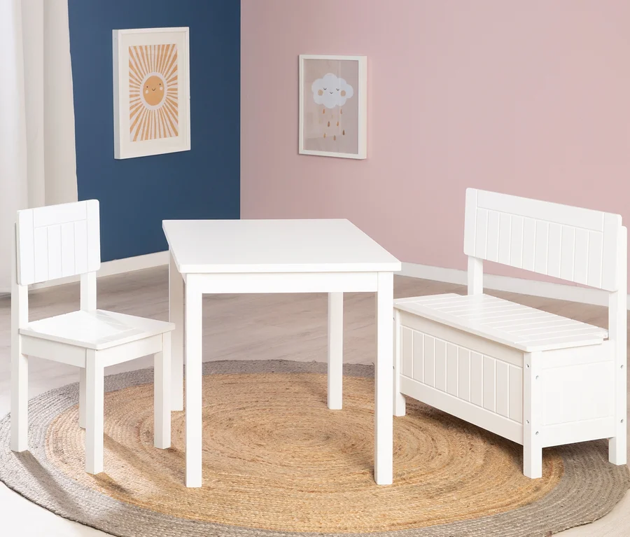 Weißer Kindertisch mit Stuhl und roba Kindertruhenbank steht auf einem runden Juteteppich im Kinderzimmer.