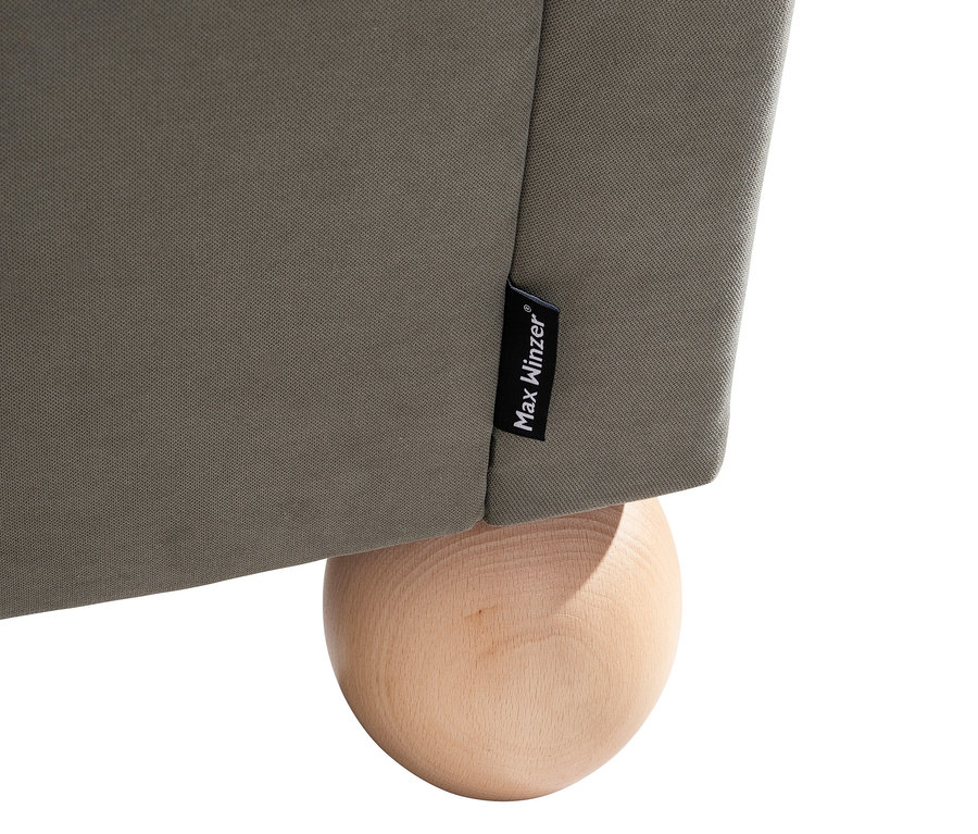 Detailansicht eines grauen XXL-Ohrensessels "Harvard" von Max Winzer® mit einem Holzbein.