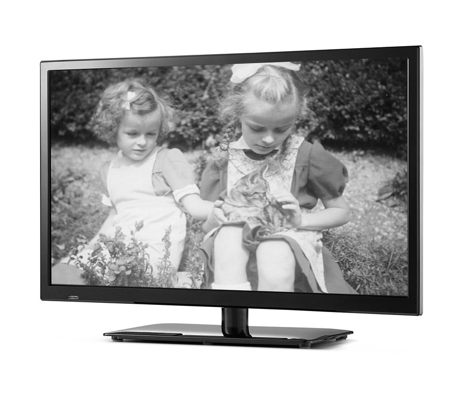 Das Schwarzweißfoto von zwei Mädchen, die im Gras sitzen, wird auf einem 23,6-Zoll-Full-HD-Fernseher MEDION® LIFE® mit integriertem DVD-Player projiziert.