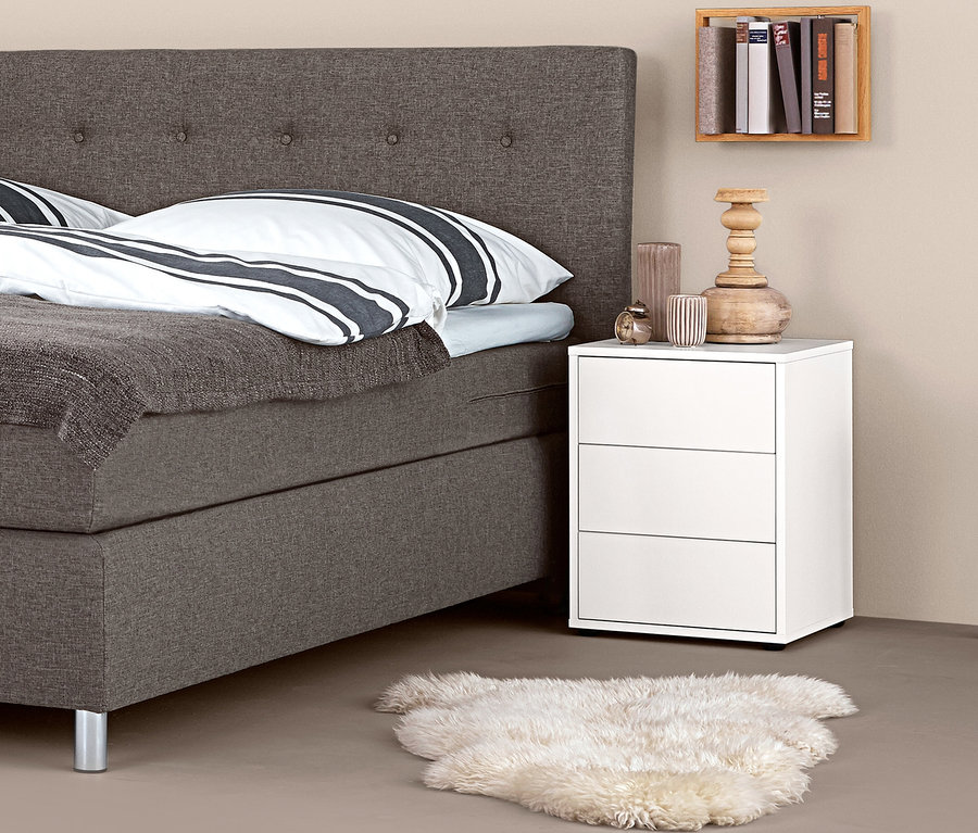 Boxspringbett mit Boxspring-Nachttisch und Dekorationen.