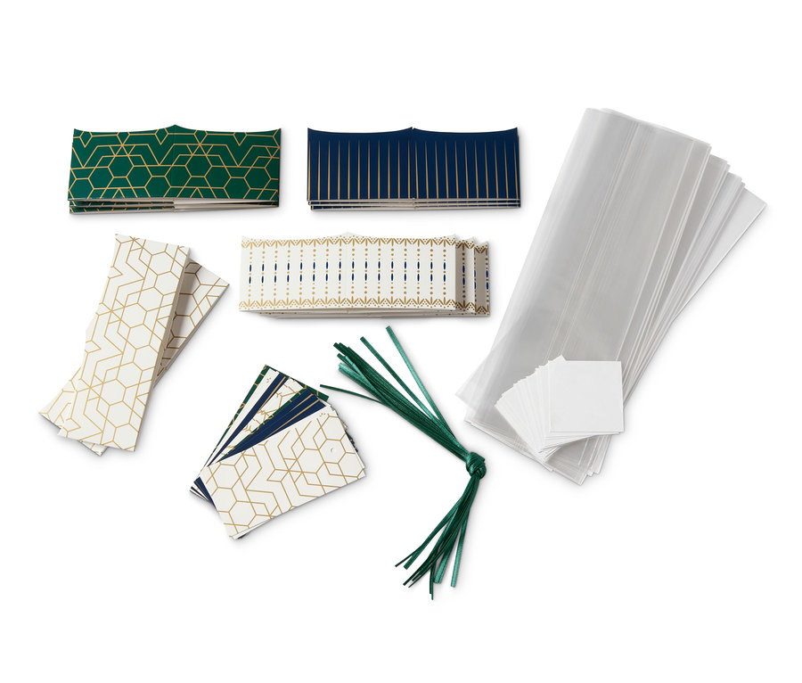 Geschenkverpackungen für Gebäck mit geometrischen Mustern in Grün, Blau und Gold auf weißem Hintergrund.
