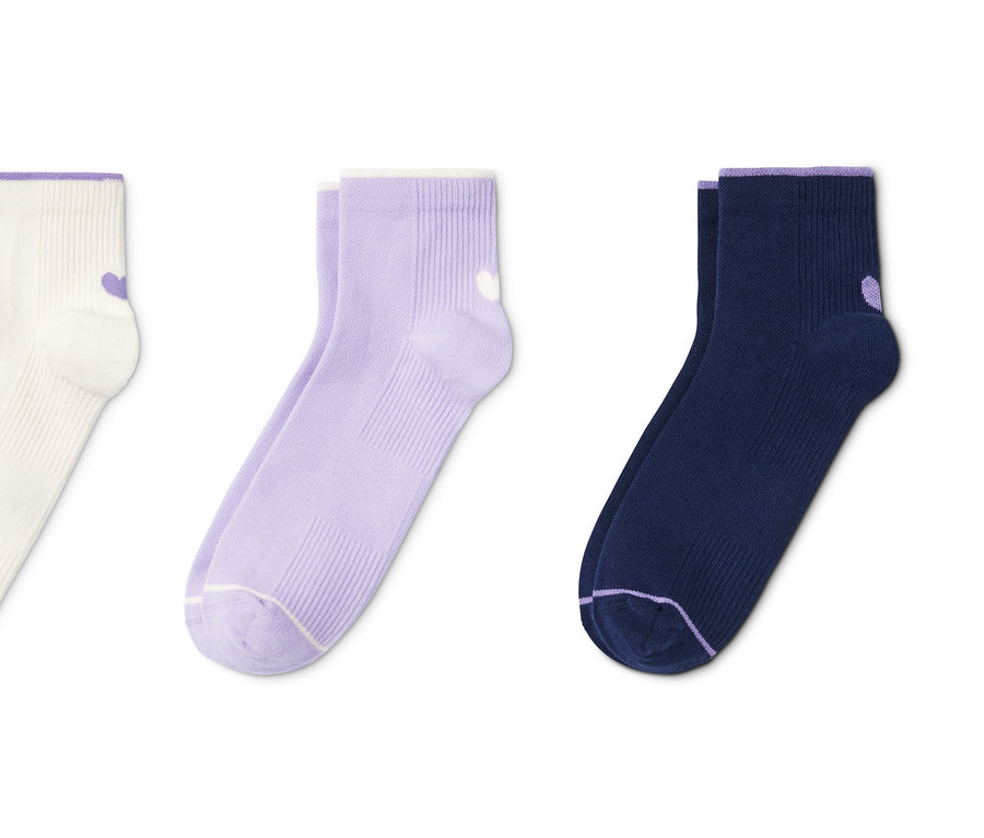 Drei Paar Socken: weiße mit lila Rand, lila und dunkelblaue mit lila Rand.