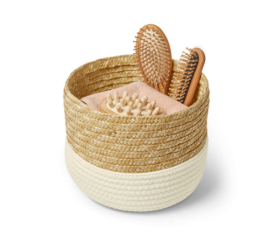 In einem Aufbewahrungskorb befinden sich zwei Haarbürsten und eine Massagebürste.