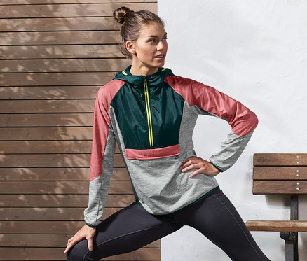 Frau dehnt sich in Halfzip-Thermojacke.