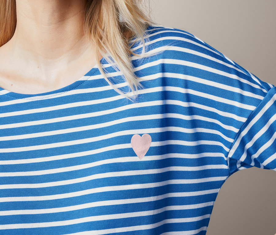 Blonde Frau trägt ein Shirt mit Streifen.