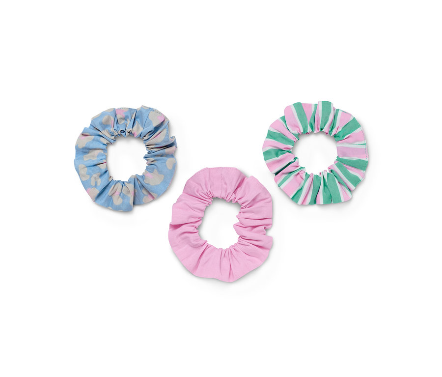 Drei Haargummis »Scrunchies«: ein blaues mit Muster, einfarbig rosa und gestreift in rosa und grün.