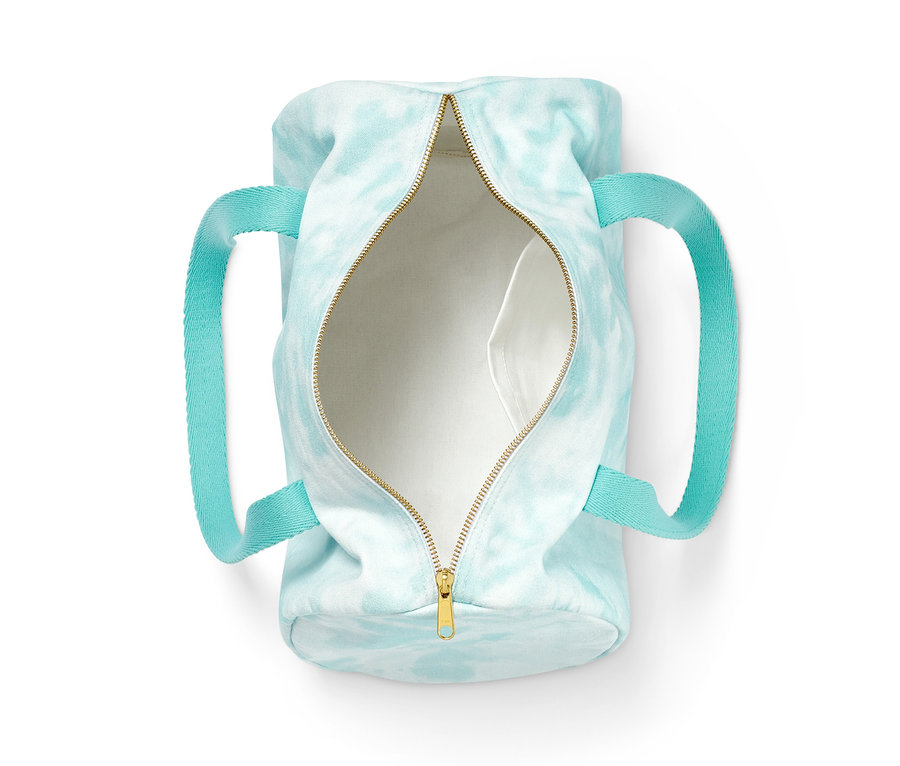 Geöffnete Tasche aus Bio-Baumwolle mit blauem Batikmuster und türkisfarbenen Griffen.