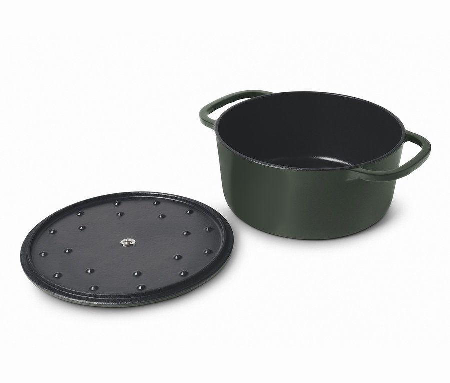 Ein grüner Gusseisen-Bräter und ein Deckel liegen nebeneinander.