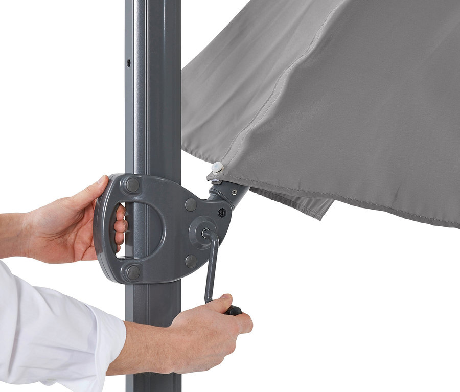 Mann justiert Kurbelmechanismus an anthrazitfarbenem Leco Ampelschirm, Ø ca. 330 cm.