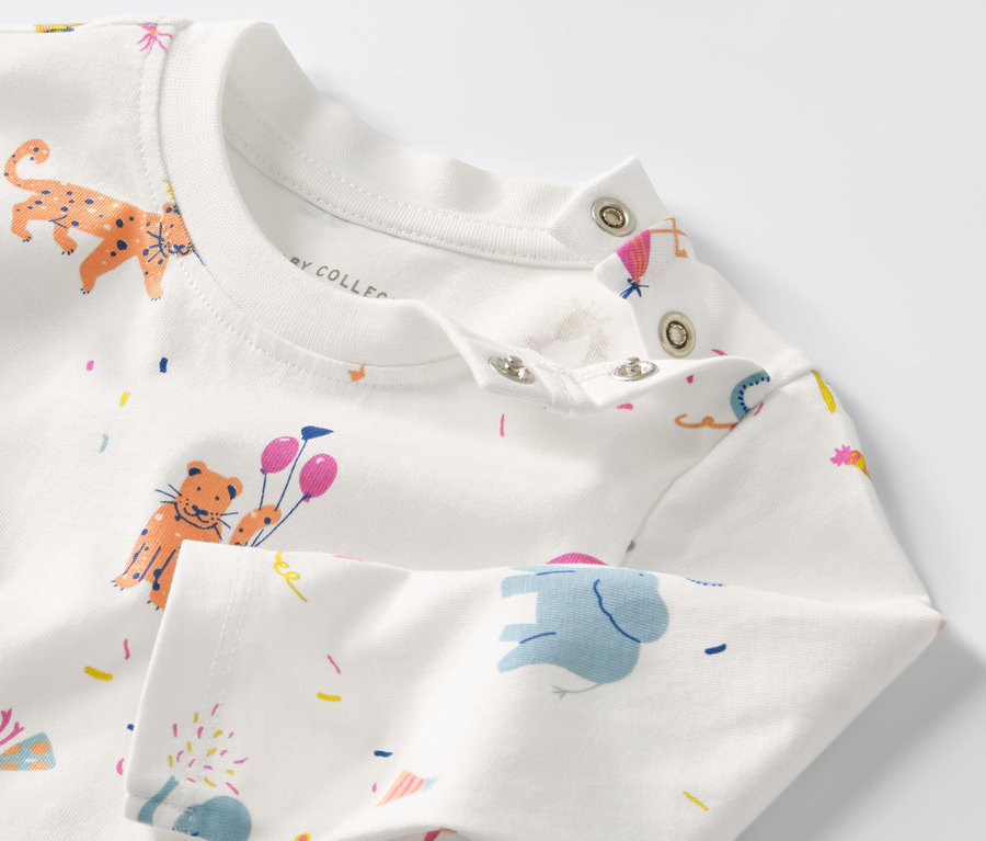 Detailansicht eines Baby-Langarmshirts mit Tier- und Konfettimuster.