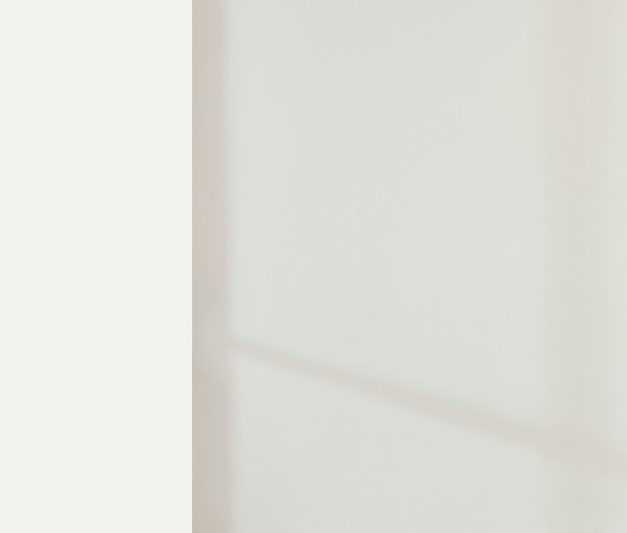 Frau steht in einem Raum und trägt ein hellbeiges T-Shirt und eine Jogginghose. Sie trägt ein NAH/STUDIO Heavy Weight Shirt und eine NAH/STUDIO Jogginghose aus nachhaltiger Baumwolle.