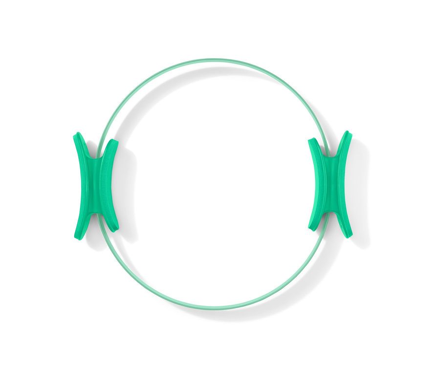 Ein grüner Pilatesring liegt auf einem weißen Hintergrund.