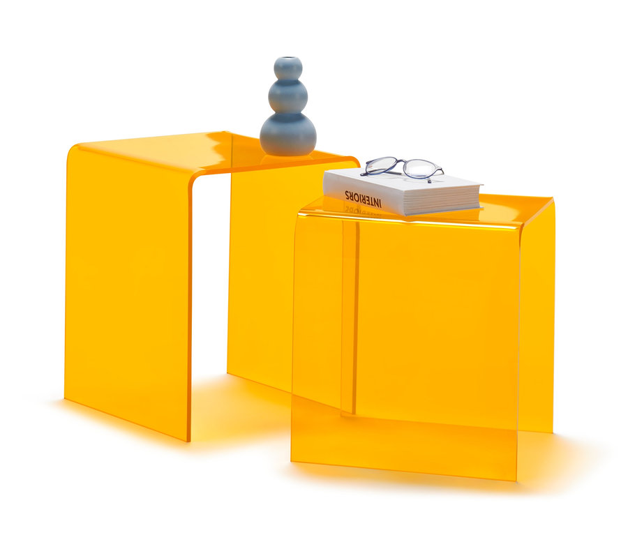 Zwei gelbe Acryl-Beistelltische, auf einem eine Vase, auf dem anderen ein Buch und eine Brille.