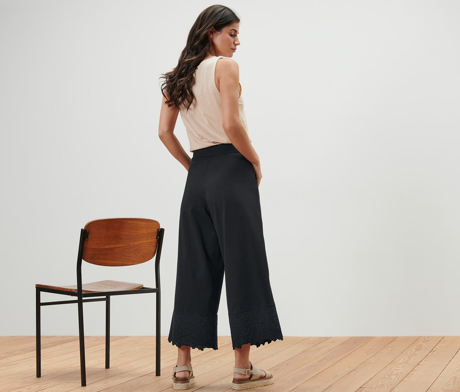 Frau von hinten mit schwarzer Culotte mit Stickerei.