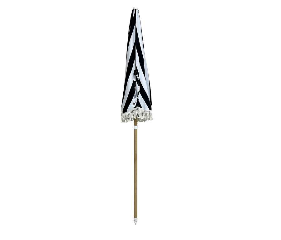 Zusammengeklappter Leco Strand-Sonnenschirm mit schwarzen und weißen Streifen und Fransen.