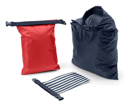 Ein roter, ein blauer und ein blau-weiss gestreifter wasserdichter Packsack, zusammengerollt auf weissem Hintergrund.