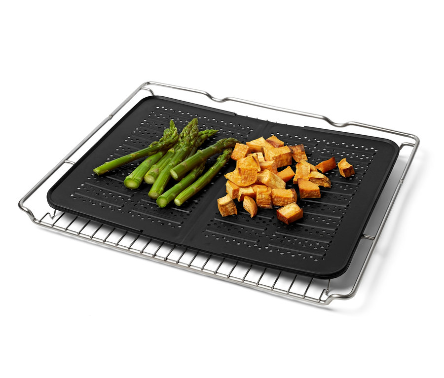 Auf einem Silikon-Backblech liegen Spargel und Süßkartoffelwürfel.