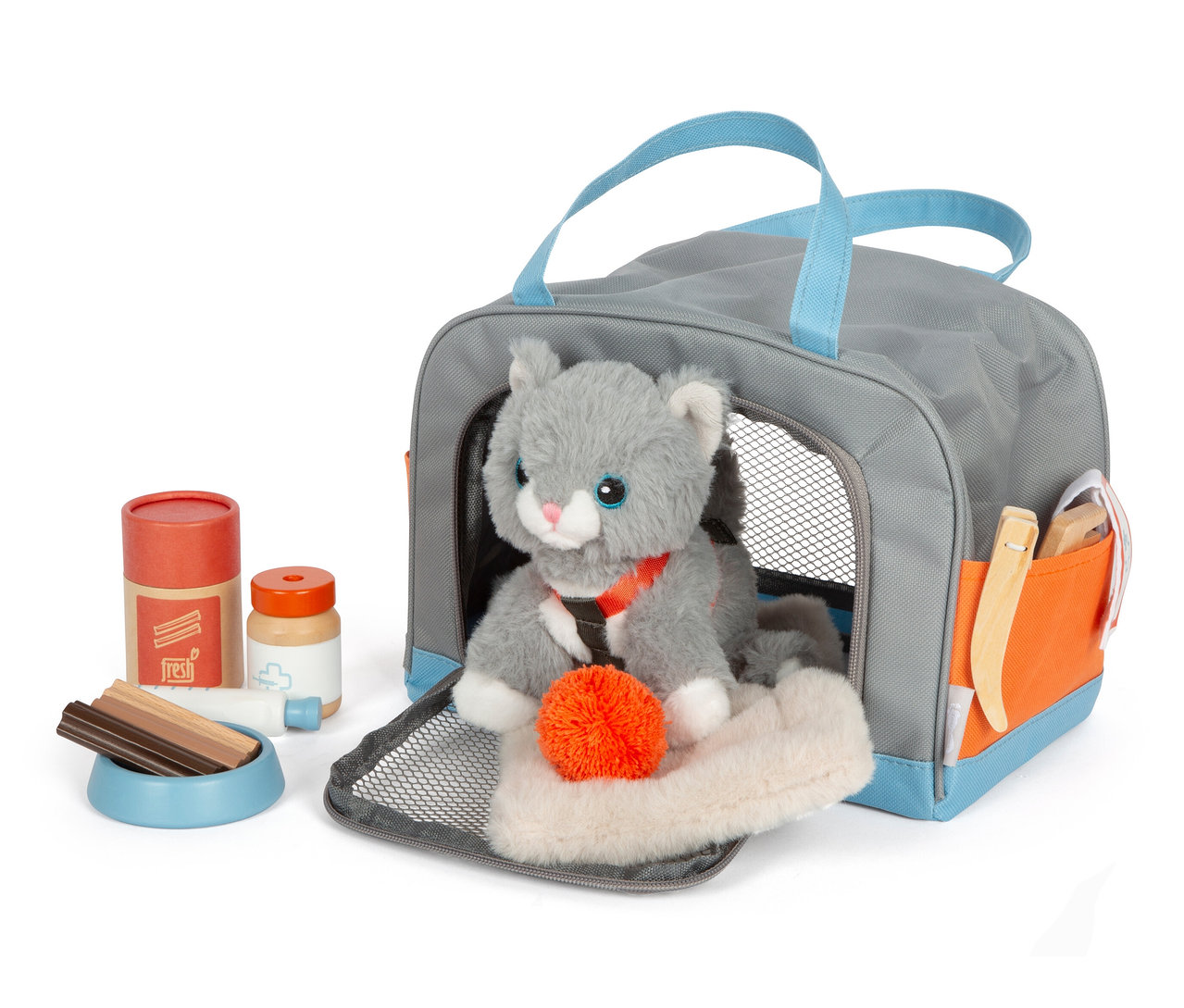 Graue Tasche mit blauen Griffen enthält eine Plüschkatze, daneben eine Schüssel mit Leckerlis und Pflegezubehör. Die small foot Katze mit Tasche und Pflege-Set ist sichtbar.
